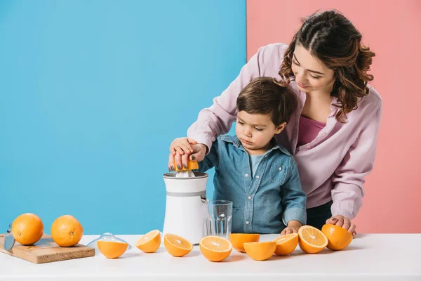 Moeder Met Schattige Zoontje Verse Jus Orange Samen Knijpen Bicolor — Stockfoto