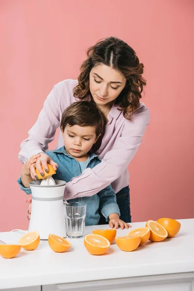 Hübsche Mutter Presst Saft Zusammen Mit Entzückendem Sohn Isoliert Auf — Stockfoto