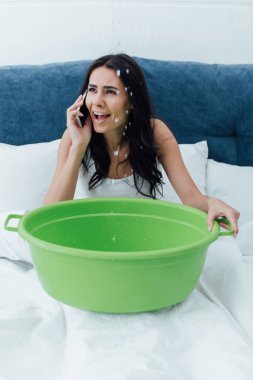 Smartphone üzerinde konuşmak ve havza yatakta tutan endişeli kız
