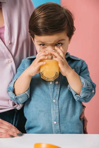 Roztomilý Malý Kluk Pití Čerstvé Pomerančové Šťávy Přitom Stát Matkou — Stock fotografie