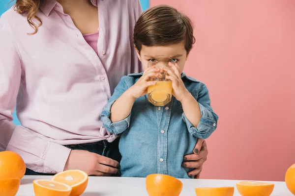 Adorable Little Boy Enjoying Fresh Orange Juice While Standing Mother — Stock Photo, Image