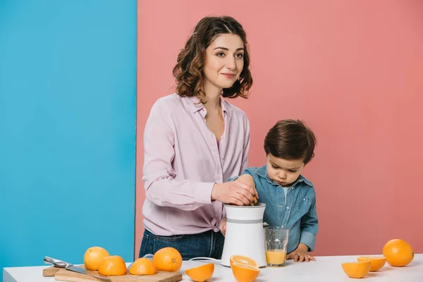 Glückliche Mutter Mit Niedlichem Kleinen Sohn Der Frischen Orangensaft Auf — Stockfoto