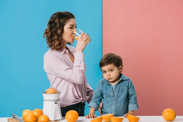 Mama Bea Suc Proaspăt Portocale Timp Stătea Fiul Drăguț Masă — Fotografie, imagine de stoc