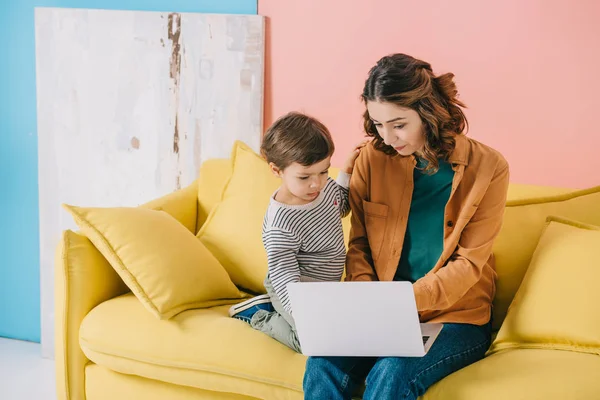Mother Cute Little Son Sitting Yellow Sofa Using Laptop — Stock Photo, Image