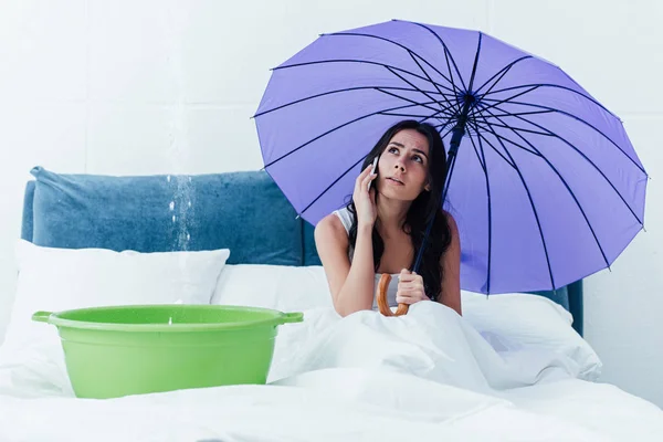 Yatak Odasında Bir Sızıntı Sırasında Telefonda Konuşurken Şemsiye Ile Esmer — Stok fotoğraf