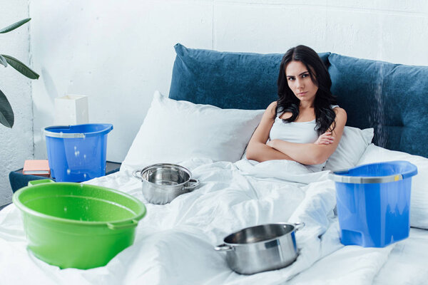 Woman lying in bed with crossed arms during water leak