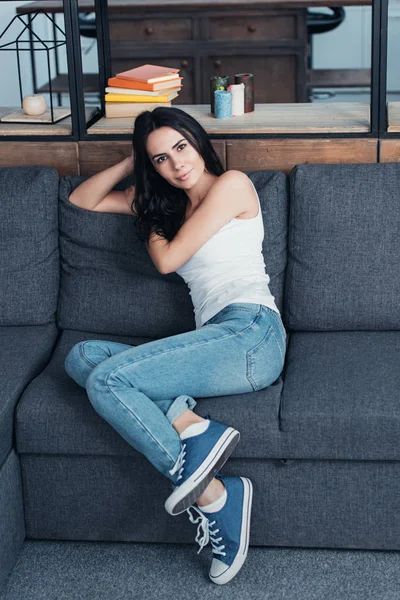 Mulher Bonita Jeans Sentado Sofá Olhando Para Câmera — Fotografia de Stock