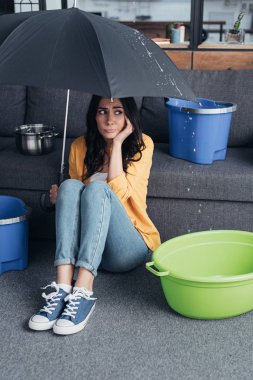 Kot pantolon şemsiye ile katta oturan üzgün kız