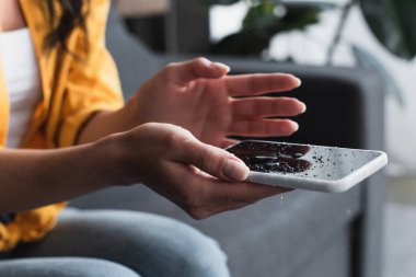 Su hasar smartphone tutan kadın görünümünü kırpılmış