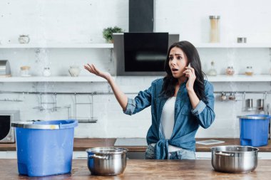 Endişeli kadın tavan ve tesisatçı çağıran gelen sızıntı suyu bakarak