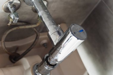 Damaged steel pipes under sink with water drops clipart