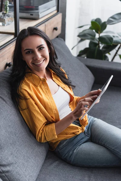 Fröhliche Frau Gelben Hemd Sitzt Auf Sofa Mit Digitalem Tablet — Stockfoto