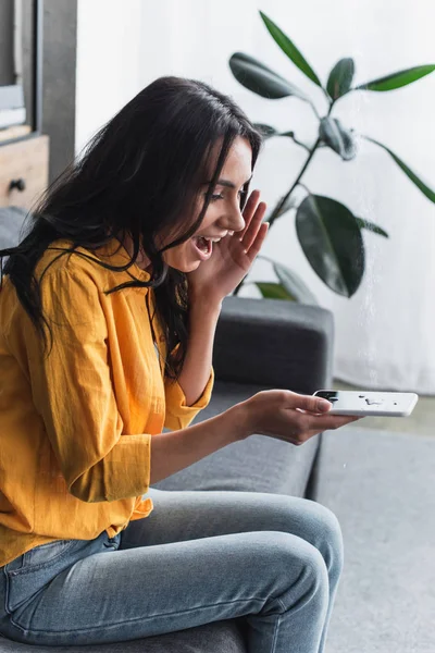 Stressed Girl Yellow Shirt Holding Water Damaged Smartphone Living Room — Stock Photo, Image