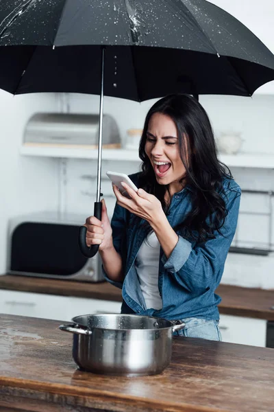 Wütende Frau Mit Smartphone Und Regenschirm Schreit Bei Wasserschaden — Stockfoto