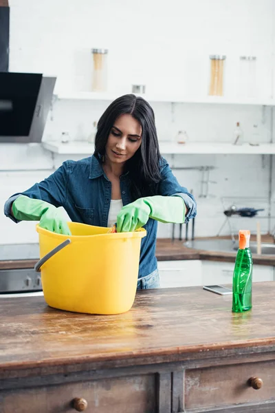 Ευχαριστημένος Γυναίκα Στα Λαστιχένια Γάντια Χρησιμοποιώντας Πλαστικό Κουβά Στην Κουζίνα — Φωτογραφία Αρχείου