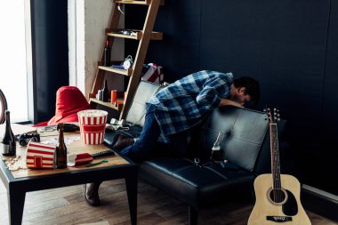 drunk man throwing up after party in messy living room clipart