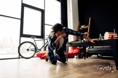 drunk man feeling nauseated while sitting of floor at home after party clipart