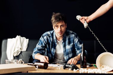 retro telefon elinde yorgun arkadaş kanepede oturan yakın tutarak adam görünümünü kırpılmış