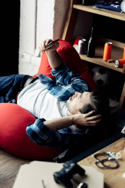 Shocked Man Lying Bean Bag Looking Smartphone — Stock Photo, Image