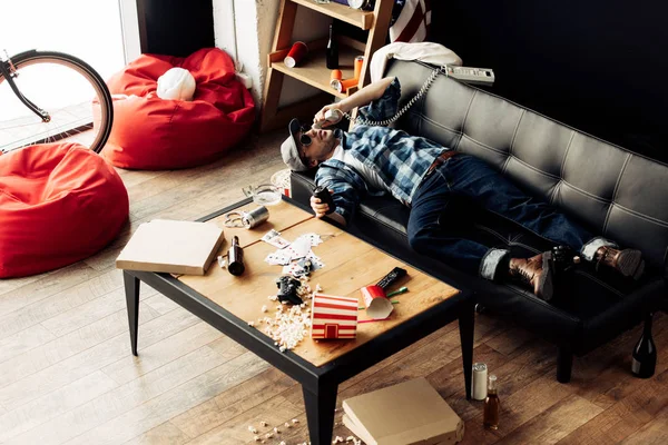 Homem Bonito Deitado Sofá Falando Telefone Sala Estar Suja — Fotografia de Stock