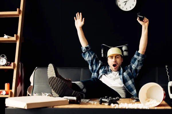 Cheerful Man Wearing Beer Helmet Celebrating Victory Messy Living Room — Stock Photo, Image