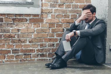 Fotoğraf tutarak ve crying on kahverengi dokulu arka plan Oda, bozukluk kavramı kederli köşede, katta oturan üzgün adam