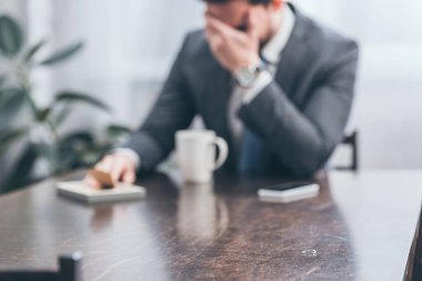 seçici odak bozukluğu kavramı kederli adam evde, zemin üzerine ağlamaya ile ahşap masa, halka
