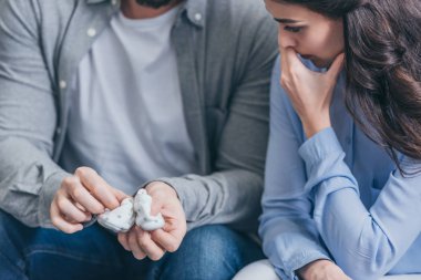 kadın ve bebek çorapları evde, holding adam bozukluğu kavramı kederli ağlama kırpılmış görünümü