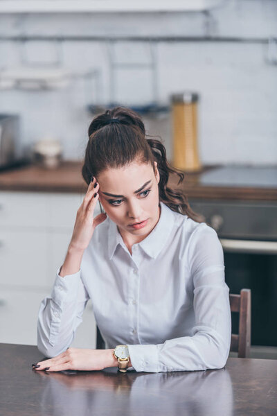 расстроен женщина сидит за столом и положить руку лоб на кухне, скорбящее расстройство концепции
