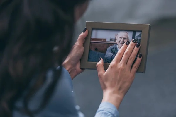 Beskuren Bild Kvinna Som Håller Fotoram Med Mogen Man Hemma — Stockfoto