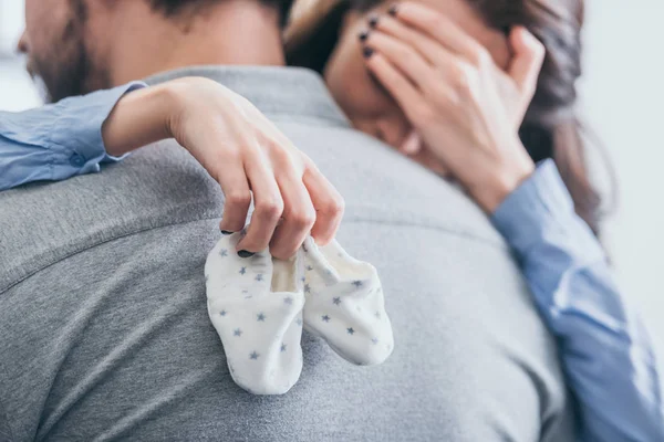 Cropped View Woman Hugging Man Holding Baby Socks Crying Room — Stock Photo, Image