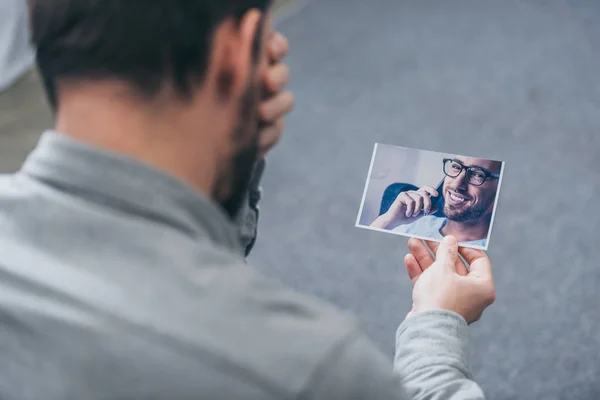 Vista Recortada Del Hombre Sentado Mirando Foto Con Hombre Casa — Foto de Stock