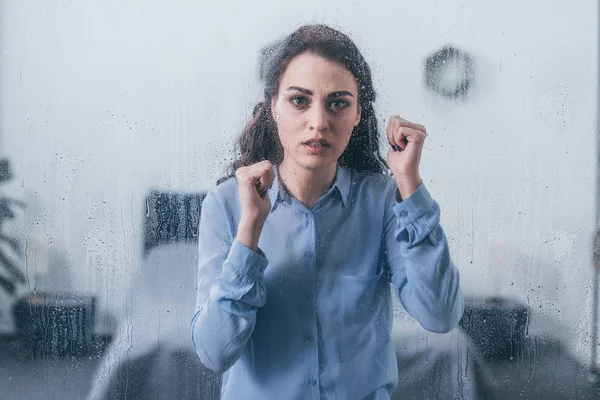 Schöne Traurige Frau Mit Geballten Fäusten Die Durch Ein Fenster — Stockfoto