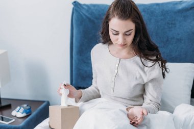 kadın yatakta yatan ve alyans tutan doku kutusu 