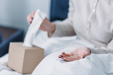 yatakta yatan ve doku için ulaşan alyans tutan kadının kısmi görünümü
