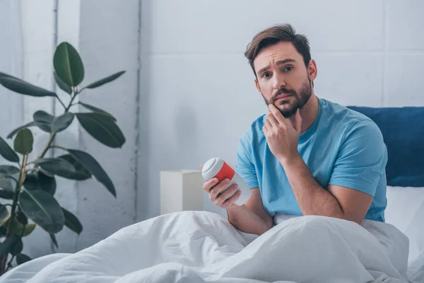 Sad Man Touching Chin Looking Camera Holding Funeral Urn Home — Stock Photo, Image