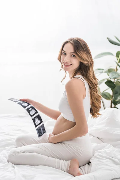 Mujer Embarazada Feliz Sentado Cama Celebración Ecografías —  Fotos de Stock