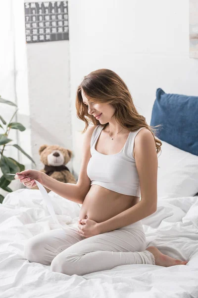 Charmante Schwangere Sitzt Auf Dem Bett Und Schaut Sich Ultraschalluntersuchungen — Stockfoto