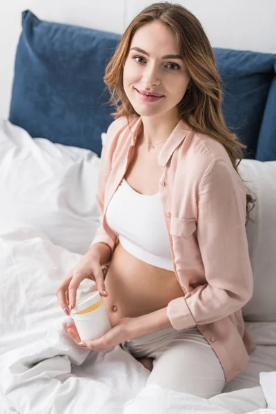 Uśmiecha Się Kobieta Ciąży Siedząc Łóżku Otwarciem Pojemnik Kremem — Zdjęcie stockowe