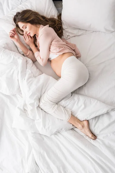 ベッドで寝ている妊娠中の女性のトップ ビュー — ストック写真