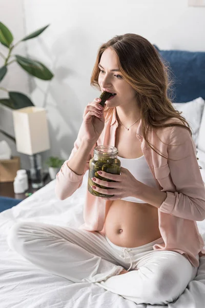 Μελαχροινή Έγκυος Γυναίκα Τρώει Τουρσιά Στο Κρεβάτι — Φωτογραφία Αρχείου