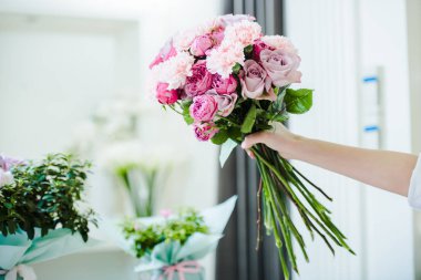 pembe buket gül ve karanfil elinde tutan kadın görünümünü kırpılmış