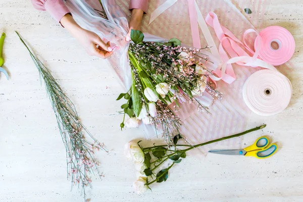 最重要的观点 女性花店包装花束与郁金香和玫瑰在桌子上 — 图库照片