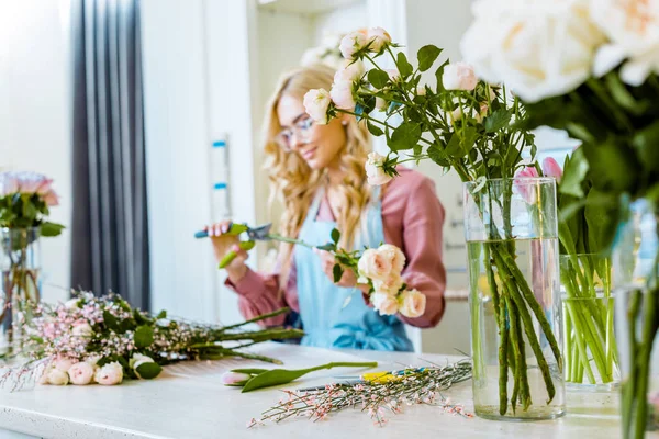 选择焦点白玫瑰与女性花店围裙安排花束在花店背景 — 图库照片