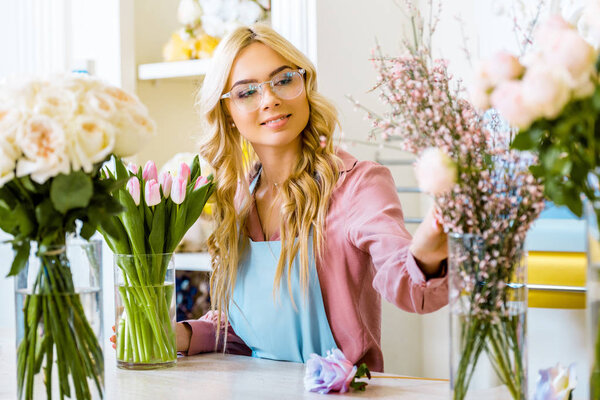 beautiful female florist with floral bouquets in flower shop