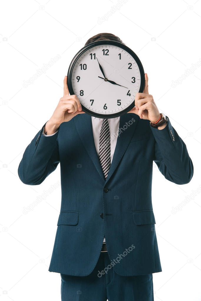 executive businessman holding clock in front of the face, isolated on white