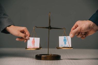 cropped view of businesspeople with male and female signs on scales of justice, gender equality concept clipart