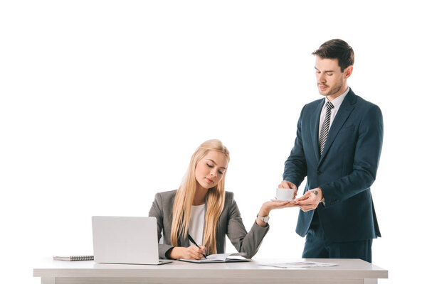 male secretary brought coffee for busy businesswoman at workplace with laptop, isolated on white