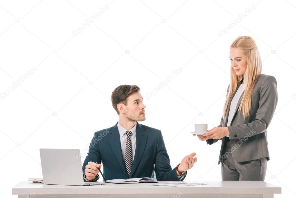female blonde secretary brought coffee for businessman at workplace with laptop, isolated on white