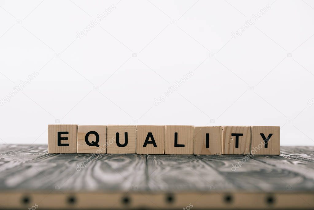 equality word made from alphabet blocks on wooden table on white